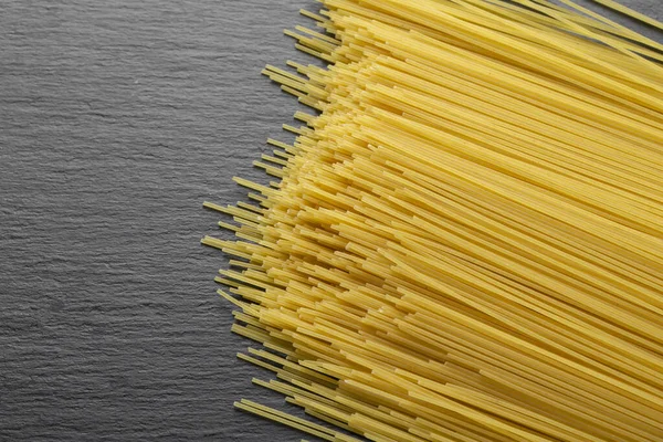 黑色背景上的黄色长意大利面 意大利食品和菜单概念 文字空间 顶部视图 — 图库照片