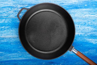 Ahşap mutfak arka planında boş dökme demir tava, metin için boşluk. Üst görünüm.