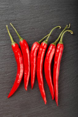 Siyah tahtada kırmızı biber var. Baharatlı yemek konsepti. Mesaj için yer var. Üst görünüm.