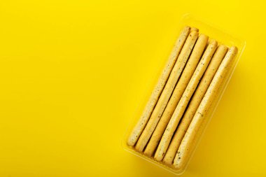 Sarı arka planda ev yapımı İtalyan Grissini Ekmeği. Mesaj için yer var. Üst görünüm.