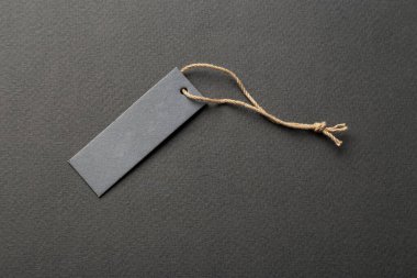 İple bağlanmış boş bir etiket. Fiyat etiketi, hediye etiketi, satış etiketi, gri arka planda izole edilmiş adres etiketi. Mesaj için yer var. Üst görünüm.