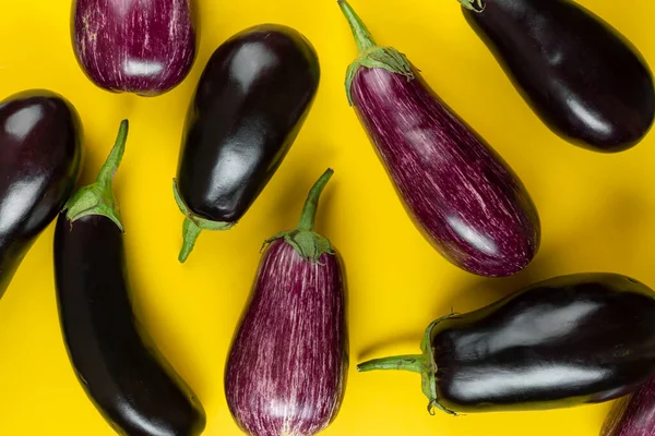 黄色の背景に紫と黒のナス 新鮮な野菜だ トップ表示 — ストック写真