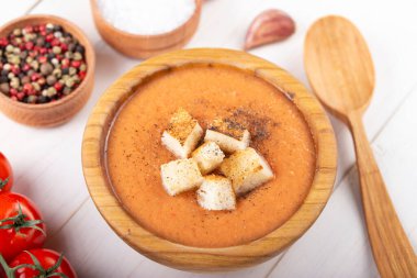 Baharatlı ev yapımı Gazpacho Çorbası. Beyaz ahşap bir masada nefis iştah açıcı domates çorbası püresi..