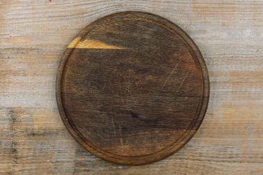 Tahta bir masanın üzerindeki boş kesme tahtası. Mesaj için yer var. Yukarıdan görüntüle.