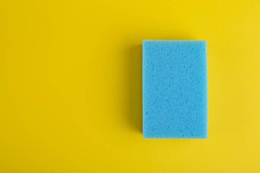 Sarı arka planda mutfak bezi. Süngerler. Temizlik için bez. Üst görünüm.