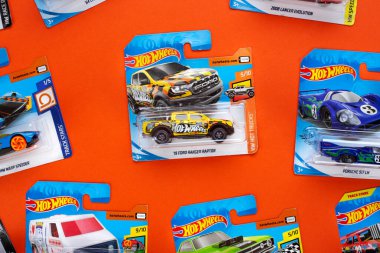 Ukrayna, Kyiv - 28 Şubat. 2020: Turuncu arka planda renkli oyuncak araba koleksiyonu grubu. Ateşli Tekerlekler. Üst görünüm.