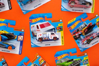 Ukrayna, Kyiv - 28 Şubat. 2020: Turuncu arka planda renkli oyuncak araba koleksiyonu grubu. Ateşli Tekerlekler. Üst görünüm.