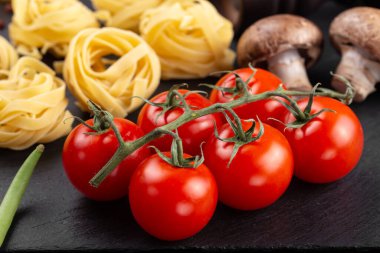 Taze domates, biber, mantar, kuşkonmaz fasulyesi, baharat ve peynirli çiğ makarna. İtalyan spagettisi için yemek malzemeleri..