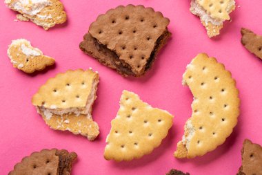 Çikolata parçalı kurabiyeler ve yakın plan pembe arkaplanlı bisküviler. Üst görünüm.