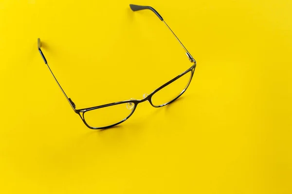 Stylish glasses on a yellow background. Health, style and business concept. Eyesight correction.