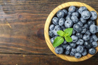Ahşap arka planda ahşap kasede taze toplanmış yabanmersini. Sağlıklı beslenme kavramı. Lezzetli yemek..