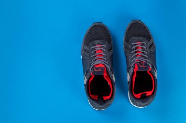 Mavi arka planda yalıtılmış spor ayakkabılar. Sıcak ayakkabı konsepti. Metin için boşluk.