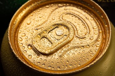 Su damlalı soğuk metal bira kutusu. Alkolik içki. Konserve içecekler. Altın renkli kapaklar.