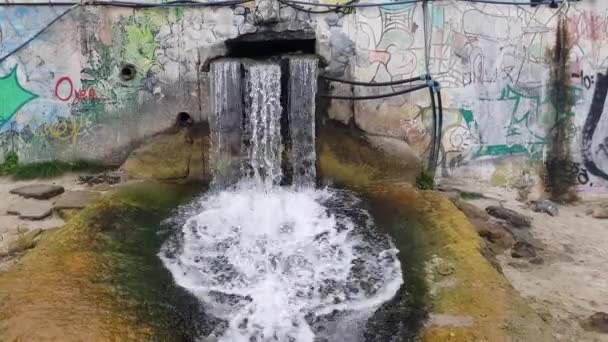 Drenaje de agua corriente limpia sobre fondo de graffiti. Concepto de arquitectura — Vídeos de Stock