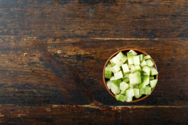 Ahşap arka planda bir kasede dilimlenmiş kabak. Sebze, malzeme ve zımba. Sağlıklı yemek..