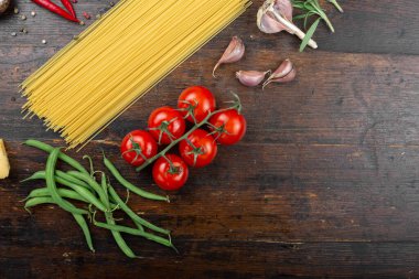 Spagetti ve içindekiler eski ve eski bir ahşap masada. İtalyan mutfağı. Lezzetli yemek..