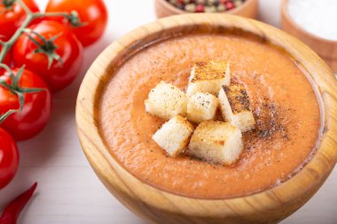 Baharatlı ev yapımı Gazpacho Çorbası. Beyaz ahşap bir masada nefis iştah açıcı domates çorbası püresi..
