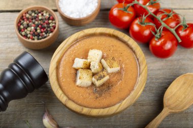 Baharatlı ev yapımı Gazpacho Çorbası. İştah açıcı yaz domates çorbası ahşap masada püre.