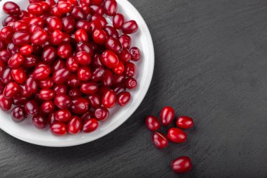 Kara tahtada beyaz bir tabakta kızılcık üzümü..