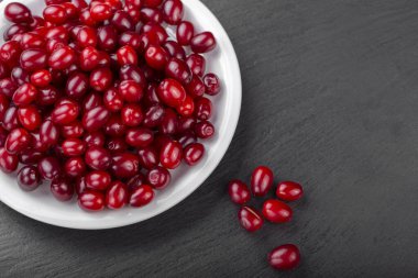 Kara tahtada beyaz bir tabakta kızılcık üzümü..