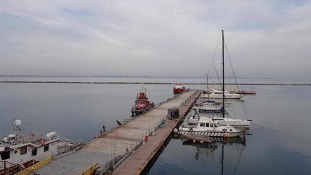 Puerto marítimo. Yates caros y botes de bomberos están amarrados en el muelle. Concepto de transporte marítimo. — Vídeo de stock