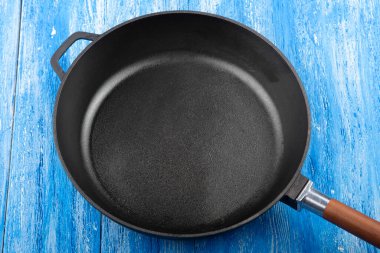 Ahşap mutfak arka planında boş dökme demir tava, metin için boşluk. Üst görünüm.