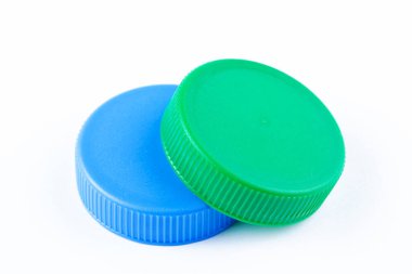 Beyaz arka planda iki plastik şişe kapağı. Plastik şişe kapaklarını geri dönüşüm ve işleme.