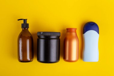 Sarı arka planda kozmetik konteynırlar. Mesaj için yer var. Üst görünüm.