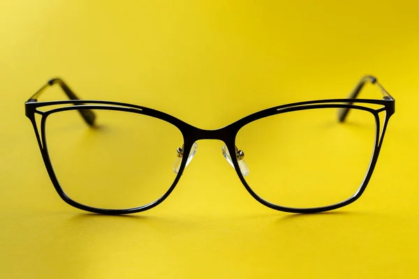 Stylish glasses on a yellow background. Health, style and business concept. Eyesight correction.