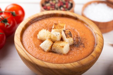 Baharatlı ev yapımı Gazpacho Çorbası. Beyaz ahşap bir masada nefis iştah açıcı domates çorbası püresi..