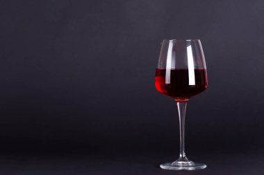 Eflatun arkaplanda bir bardak şarap. Mesaj için yer var. Şarap tatma ve içme kültürü konsepti. Alkolik içecek.