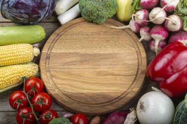 Ortasında boş bir kesim tahtası olan sebze arkaplanı. Sağlıklı beslenme. Hasat konsepti. Mesaj için yer var. Üst görünüm.