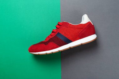 Renkli bir arka planda bir çift spor ayakkabısı. Çok renkli arka planda yeni spor ayakkabılar, kopyalama alanı. Sıradan moda spor ayakkabıları kırmızı renkler. Biçim konsepti.