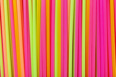 Meyve suyu için renkli borular ve turuncu arka planda kokteyller. Kokteyl partileri. Mesaj için yer var. Üst görünüm.