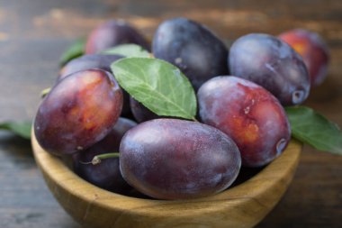 Tahta masadaki bir tabakta tatlı erikler. Sağlıklı meyve.