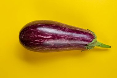 Sarı arka planda çiğ mor patlıcan. Taze sebzeler. Mesaj için yer var. Üst görünüm.