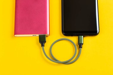 Sarı Arkaplan Görünümünde Pembe Güç Bankasıyla Akıllı Telefon Şarjı