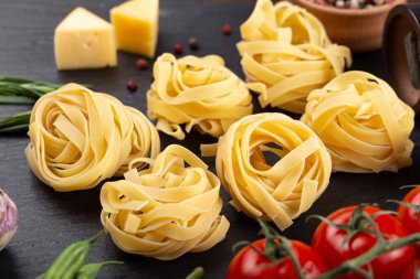 Taze domates, biber, mantar, kuşkonmaz fasulyesi, baharat ve peynirli çiğ makarna. İtalyan spagettisi için yemek malzemeleri..