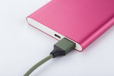 Mobil cihazları şarj etmek için güç bankası. Pembe akıllı telefon şarj aleti ve elektrik bankası. Batarya. Beyaz arkaplandaki mobil aygıtlar için dış pil.