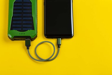Sarı Arkaplan Görünümünde Güç Bankası ile Akıllı Telefon Şarjı