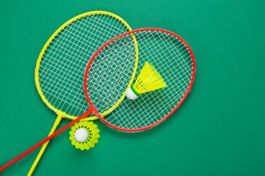 İki mekik horozu ve badminton raketi. Yeşil bir arka planda. Yaz tatili kavramı.