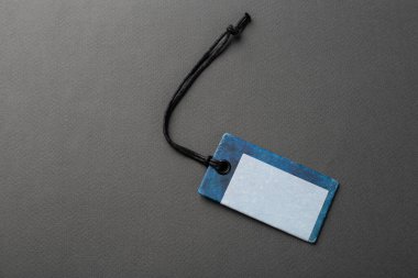 İple bağlanmış boş bir etiket. Fiyat etiketi, hediye etiketi, satış etiketi, gri arka planda izole edilmiş adres etiketi. Mesaj için yer var. Üst görünüm.