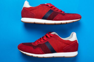 Renkli arka planda bir çift şık kırmızı spor ayakkabı, metin için boşluk. Üst görünüm.