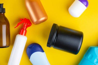 Sarı arka planda kozmetik konteynırlar. Üst Manzara. Güzellik ve kişisel bakım konsepti