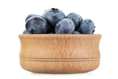 Beyaz arka planda izole edilmiş ahşap bir kasede taze hasat yaban mersini. Dosya kırpma yolu içeriyor.