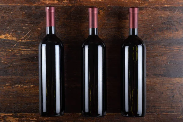 Três Garrafas Vinho Tinto Num Fundo Madeira Bebida Alcoólica Vista — Fotografia de Stock