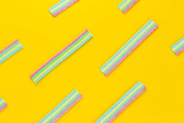 Meyan kökü şekeri. Sarı arka planda farklı aromalı tatlı jelibonlar. Üst görünüm.