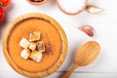 Baharatlı ev yapımı Gazpacho Çorbası. Beyaz ahşap bir masada nefis iştah açıcı domates çorbası püresi..