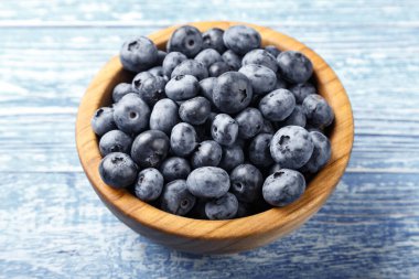 Tahta bir kasede taze toplanmış yabanmersini. Sağlıklı meyve, organik gıda, antioksidan, vitamin, mavi gıda..