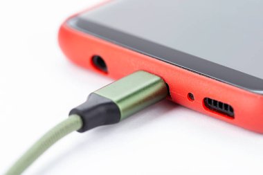 Beyaz arkaplan üzerinde USB kablosu ile akıllı telefon Charger 'a bağlanır.